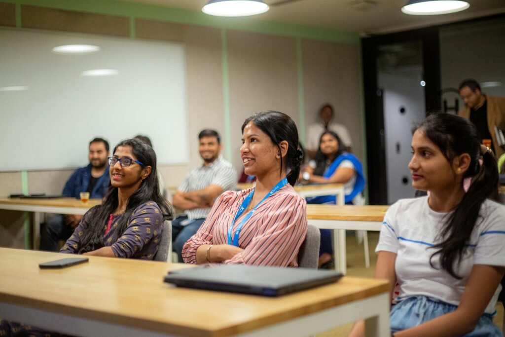 A diverse group of adults attentively listening during an office seminar or workshop.